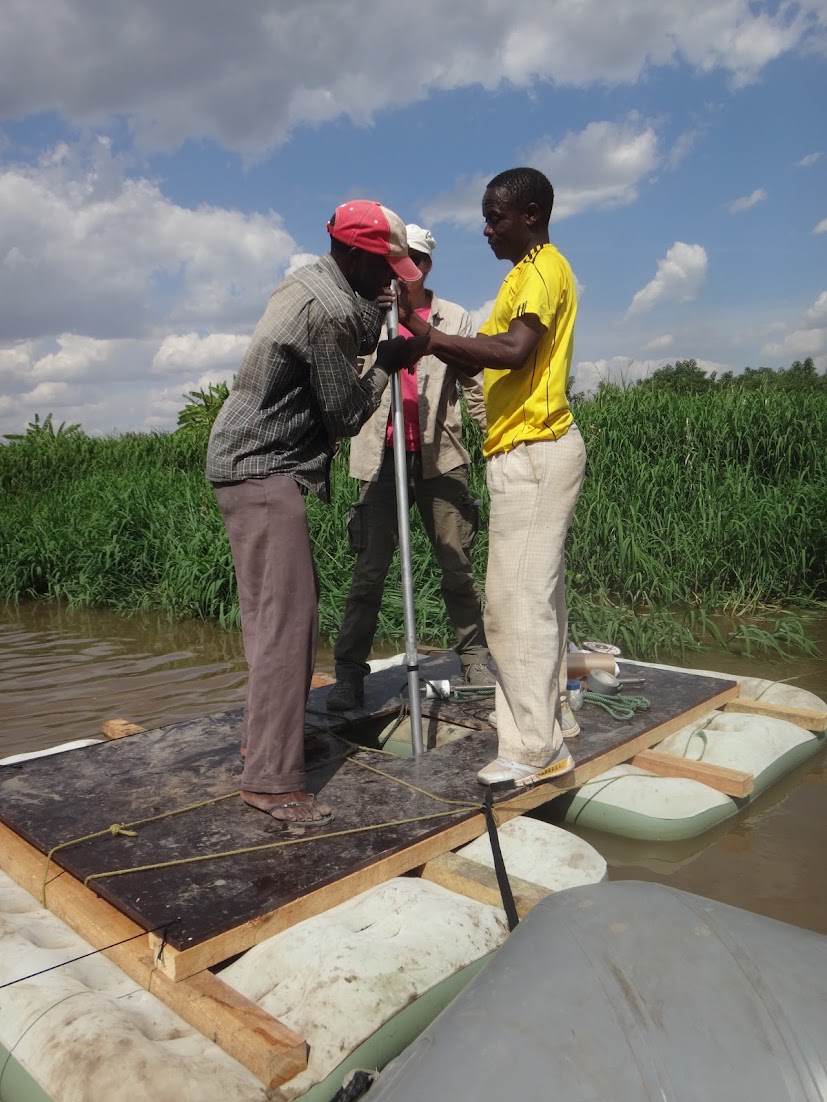 Two members of the crew driving a coring tube from the raft
