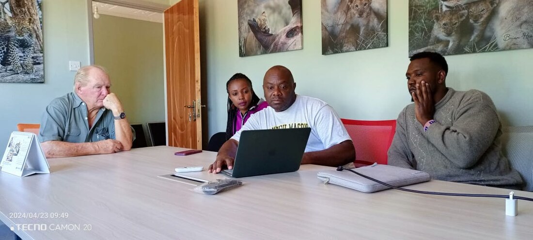 Four people around a table working through results on a laptop